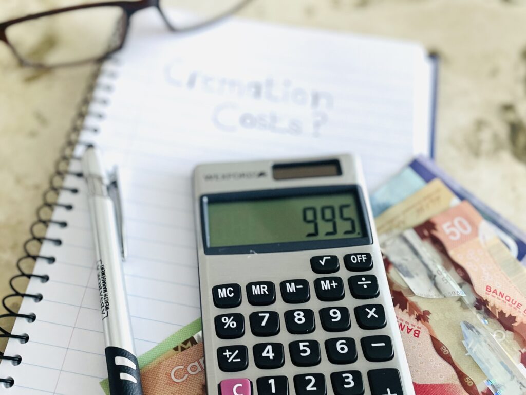 Photo of calculator being used to organise funeral costs