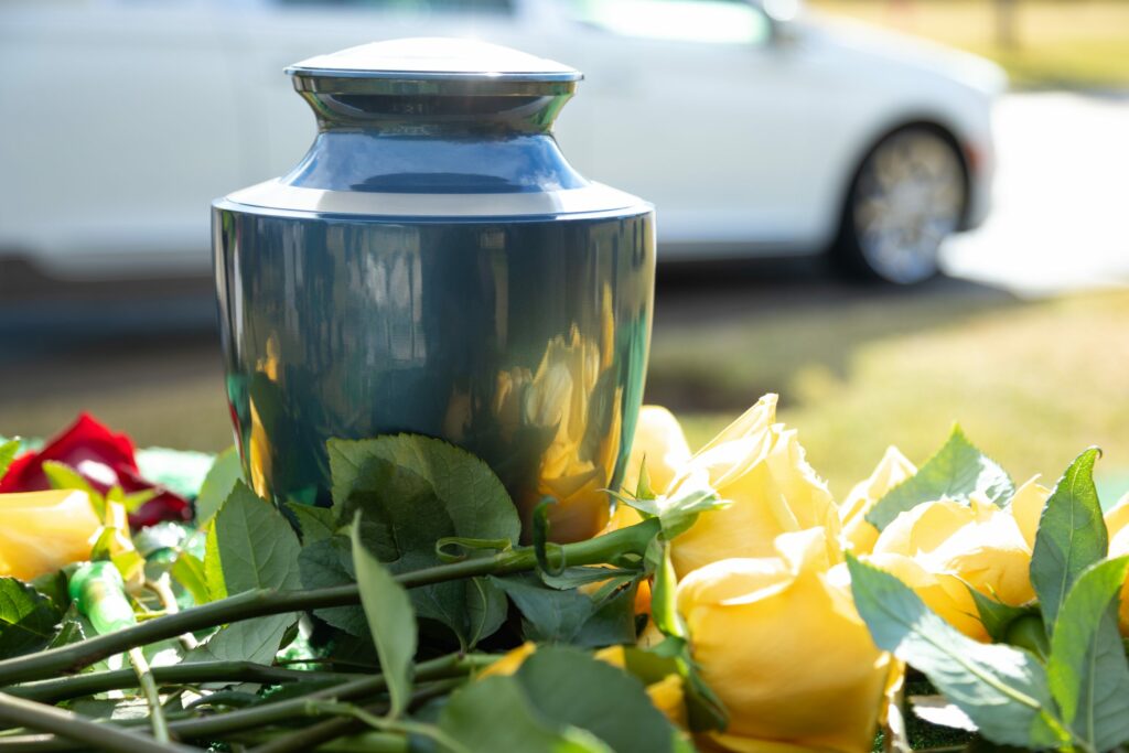 Close up photo of a cremation urn and some roses